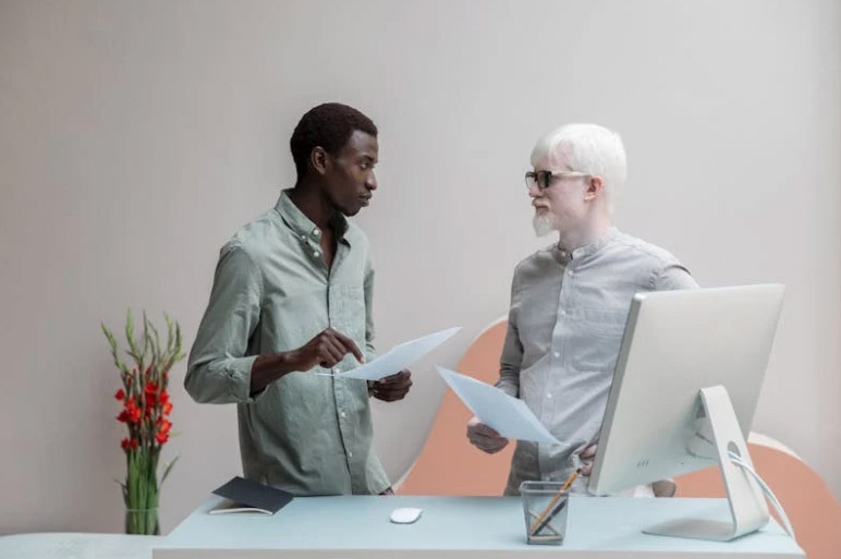Multiracial coworkers with papers in office
