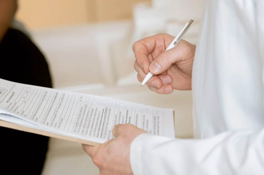 Person Holding Paper And Pen