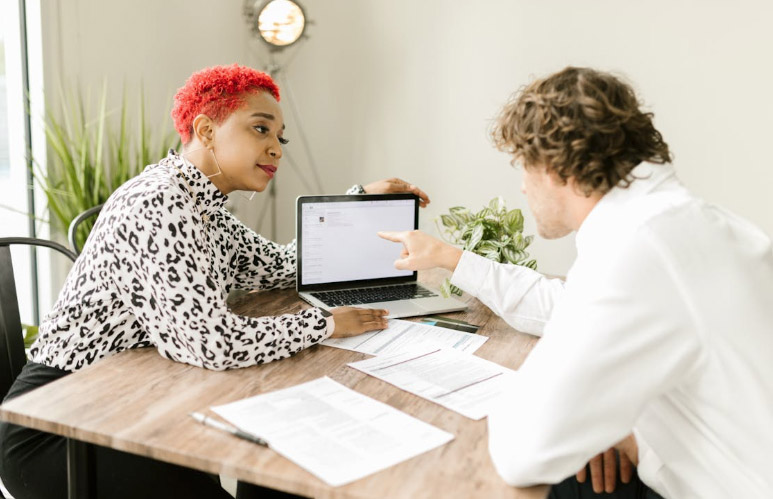Woman Showing a Laptop to a Person