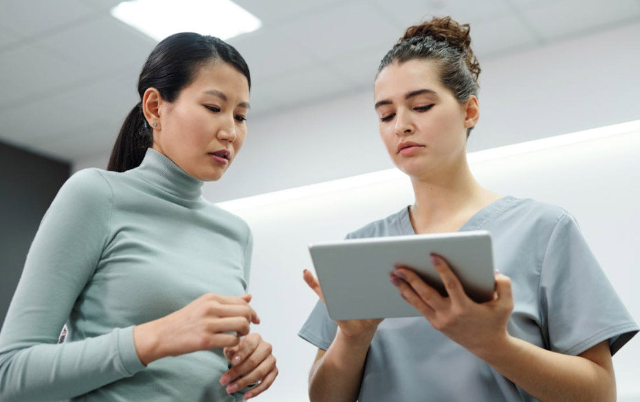 a doctor and a patient looking at a tablet 