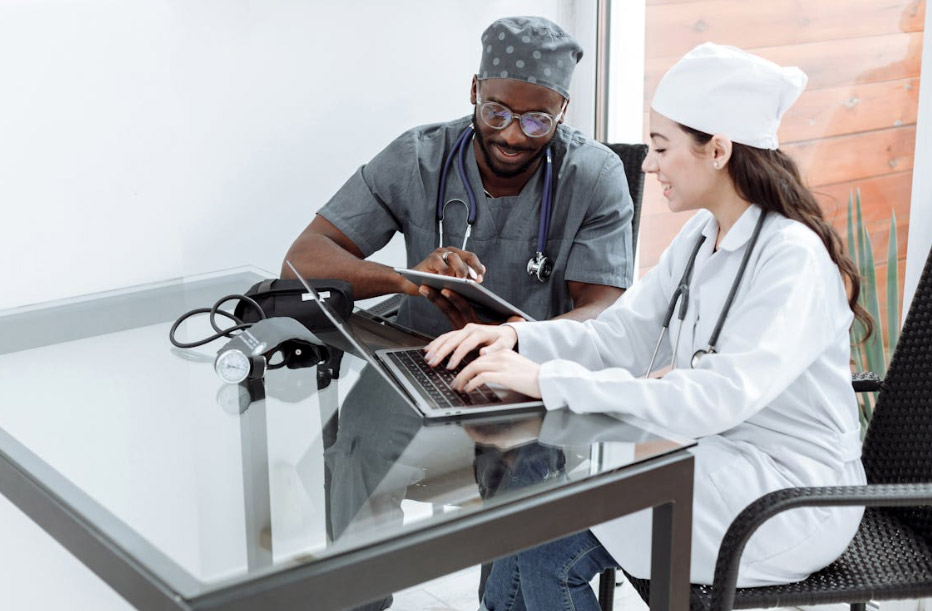 healthcare professionals working on their gadgets while sitting next to each other