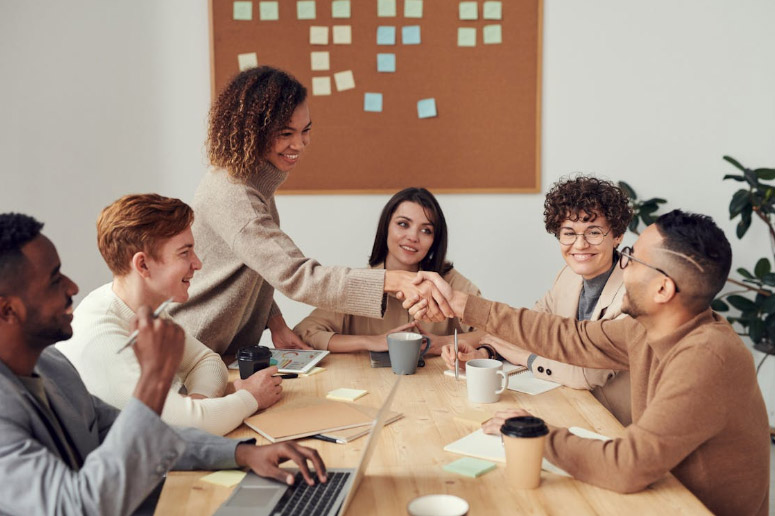 Patient 360 | How Do ACOs Manage Quality Reporting Across Multiple EHR Systems? Colleagues Shaking each other's Hands