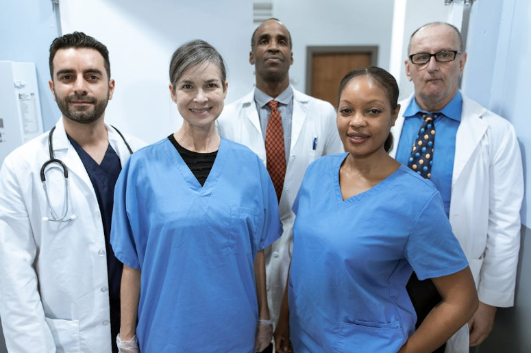 Patient 360 | How Do ACOs Manage Quality Reporting Across Multiple EHR Systems? Health Care Professionals Smiling at the Camera