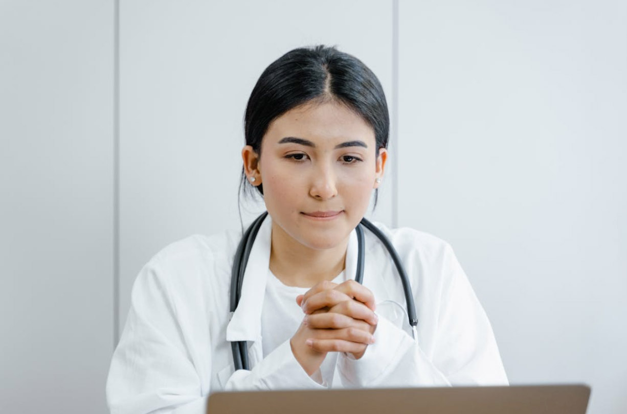 Woman in White Scrub Suit on her Computer