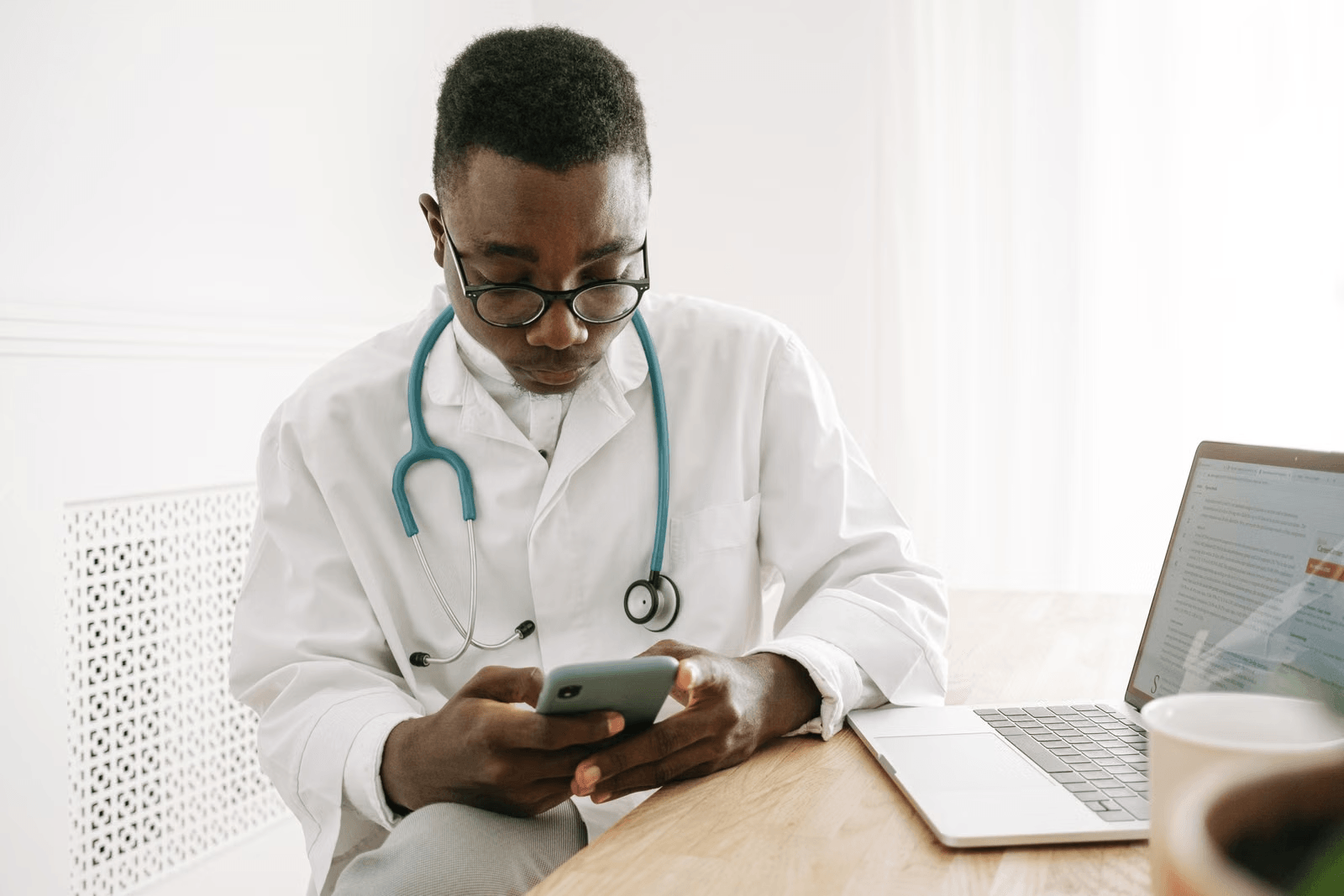 Doctor reviewing digital reporting information beside a laptop
