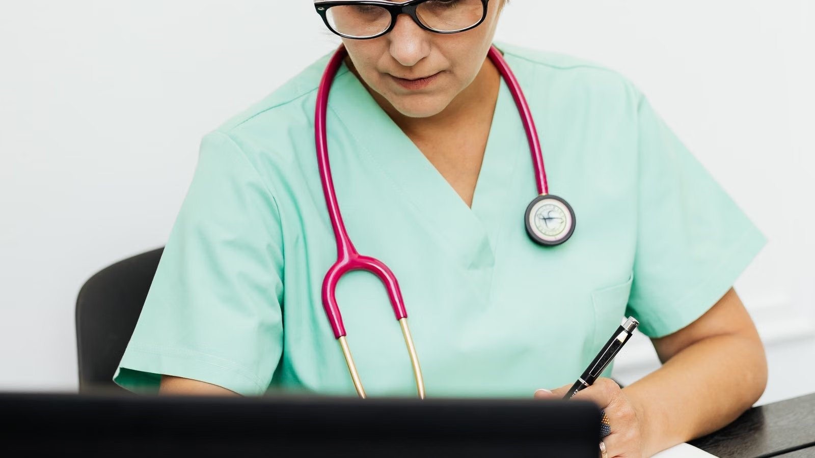 Doctor using a laptop to review clinical documentation in a medical office
